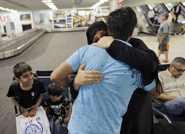 Wagma Nargis Khan hugs her brother Hekmatullah Khan inside the baggage claim at John Glenn International Airport in Columbus. Wagma and her family are refugees from Afghanistan and will be living with her brother in Hiliard.   (Adam Cairns / The Columbus Dispatch)